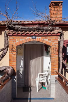Old grapevine branch enclosing village house entry. Plants valued for decoration and delicious fruits. La Garganta village, Banos de Montemayor district, Extremadura, Spain