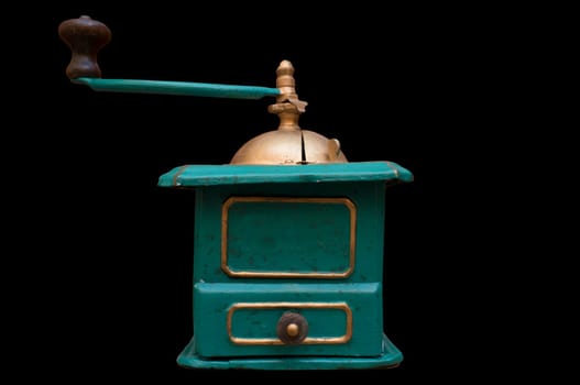 Old manual coffee grinder painted gold and green. Selective focus