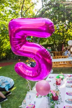 Happy Birthday decoration. Birthday Balloon At Summer Garden Party. Number Five Violet Balloon.