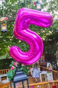 Happy Birthday decoration. Birthday Balloon At Summer Garden Party. Number Five Violet Balloon.