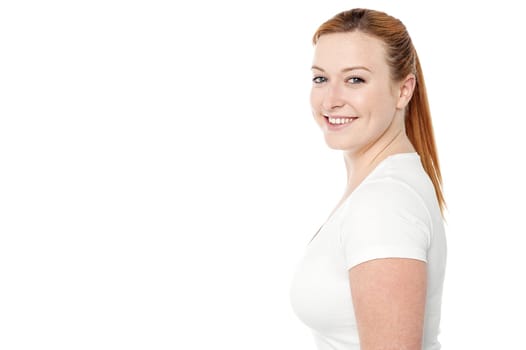 Side pose of happy woman looking at camera