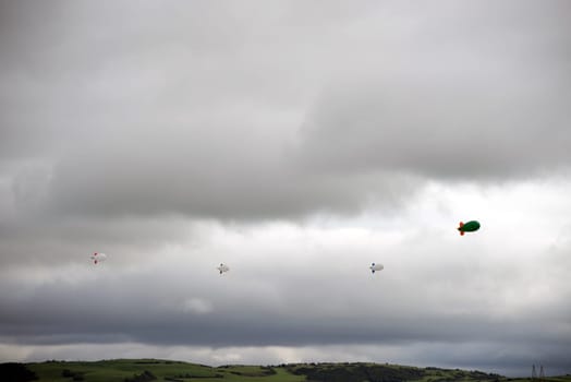 clouds full of air blimps high in the grey sky