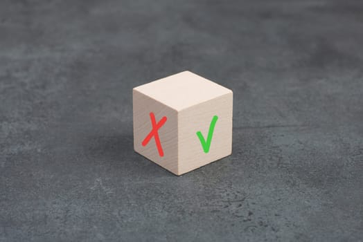 Wooden cube with a tick and a cross, desicion making, choosing between options