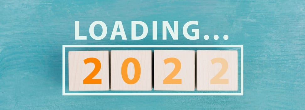 2022 is standing in orange colored letters on wooden cubes, the word loading is standing above
