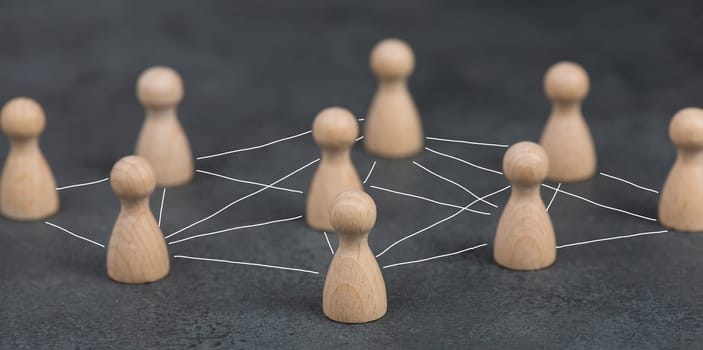 Wood figures, roup of people connecting through a web, business networking and communication