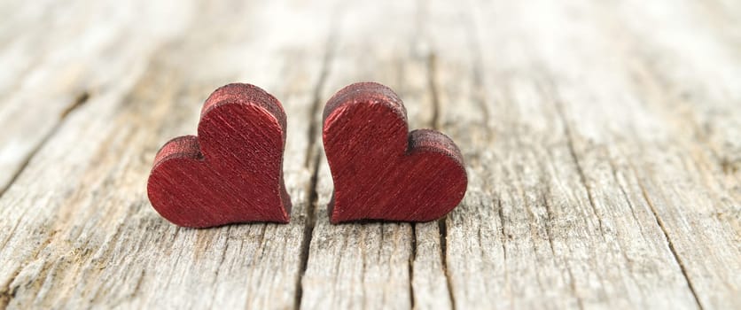 Two wooden hearts on the cracked rustic wooden table