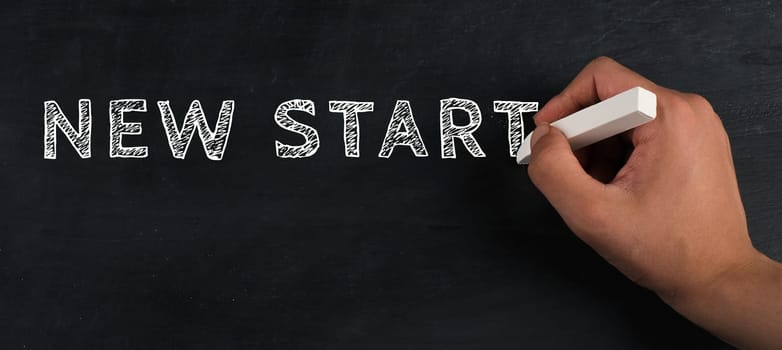 The words new startare standing on a chalkboard, hand writing