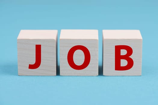 The word job is standing in red letters on wooden cubes, blue background