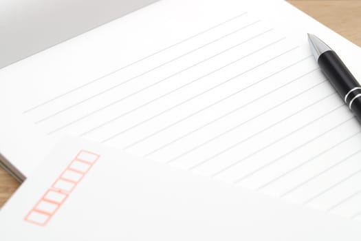 Japanese writing letter paper with ballpoint pen on wooden background