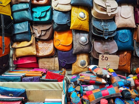 Handmade colourful leather bags and purses on display at traditional souk - street market in Morocco.