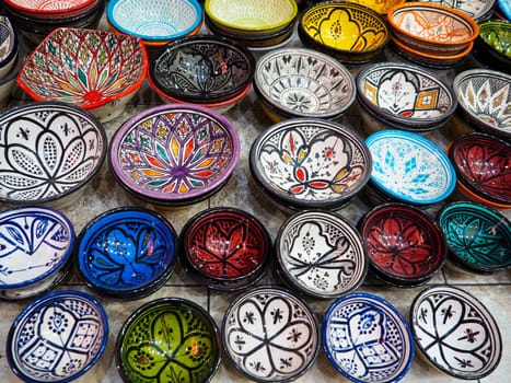Handmade colourful decorated bowls or cups on display at traditional souk - street market in Morocco.