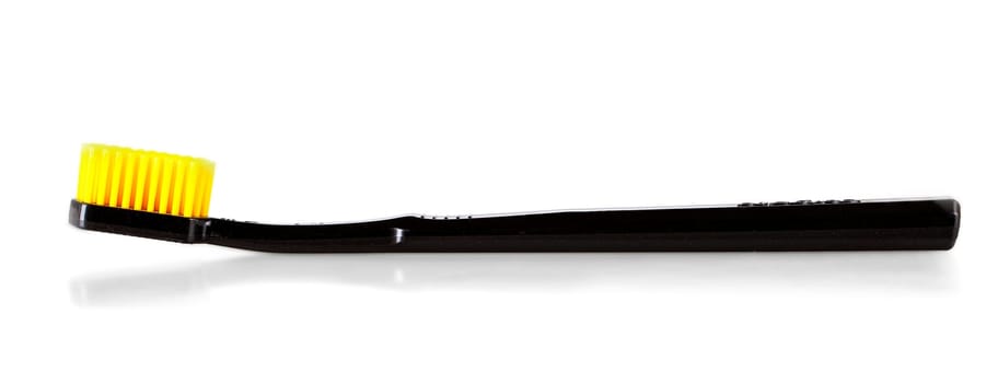 The black toothbrush with yellow bristles  isolated on white