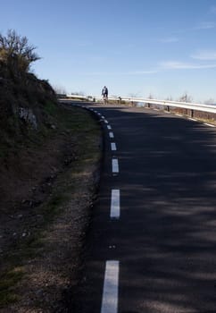 Mature biker ascending mountain pass. Road biking by Extremadura, Spain