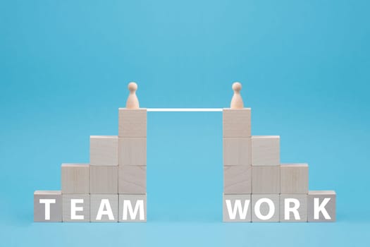 Two wooden people connect to build a team, working together