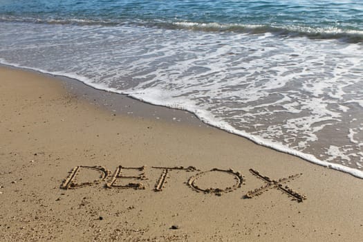 Detox word written in the sand