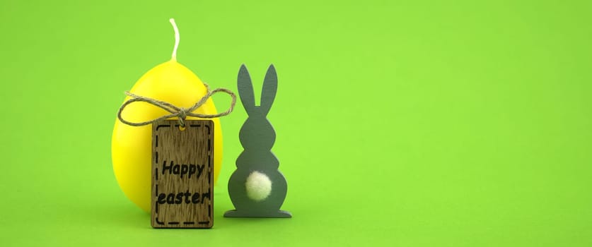 Minimalistic style Easter banner and wooden label with text "Happy Easter"" on green background with free copy space for text"