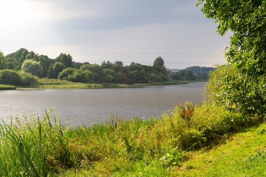 A beautiful view of the peaceful river. Summer day at the river in rural countryside.