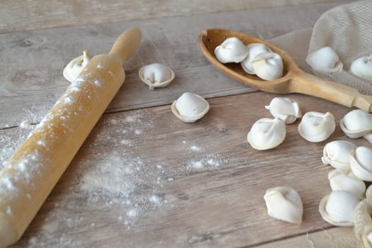 Homemade dumplings raw lie on a white wooden table in shabby style with copy space