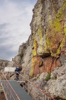 Alburquerque, Spain - Feb 21st, 2021: Visitors at San Blas rock shelter with prehistorical paintings at Sierra de San Pedro. Alburquerque, Badajoz, Extremadura, Spain