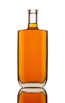 front view closeup of square modern shape cognac bottle with no label isolated on white background with reflection