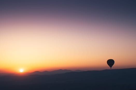 landscape with hot air balloons black silhouette rising up to the sky at sunrise with beautiful high mountain panorama in the background