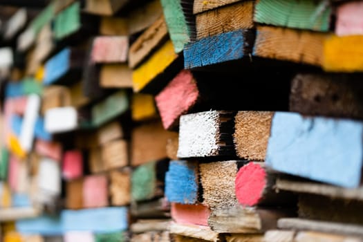 closeup perspective view of stacked wooden planks decorated with paint in different colors