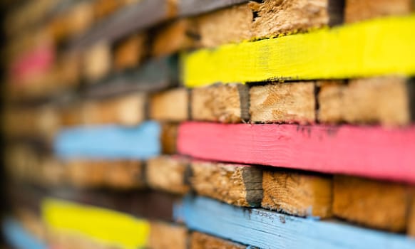 closeup perspective view of stacked wooden planks decorated with paint in different colors