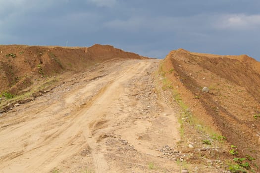 heap in the quarry sand against the blue sky