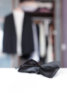 Bow tie with open closet and tuxedo. Getting ready for formal night. With isolated place for text.