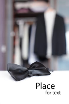 Bow tie with open closet and tuxedo. Getting ready for formal night. With isolated place for text.