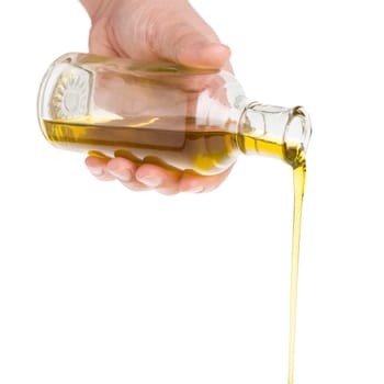 Male hand holding a bottle. Oil pouring from a bottle.