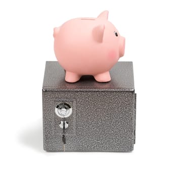 Pink ceramic piggy bank standing on a safe. Isolated on white background