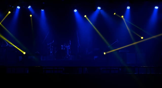 Blue and yellow stage spotlights with smoke. Floodlights of concert scene