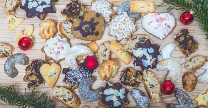 Homemade Christmas cookies, powdered sugar and Christmas bauble on a rustic wooden table
