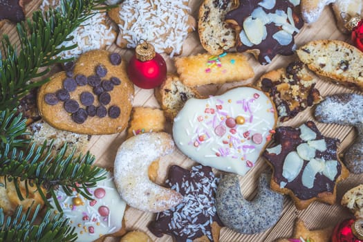 Homemade Christmas cookies, powdered sugar and Christmas bauble on a rustic wooden table