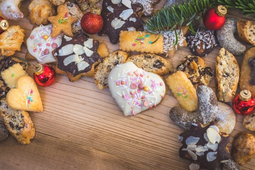 Homemade Christmas cookies, powdered sugar and Christmas bauble on a rustic wooden table. Copy Space.