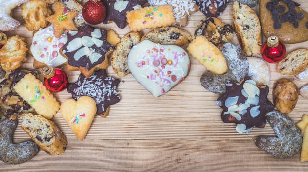 Homemade Christmas cookies, powdered sugar and Christmas bauble on a rustic wooden table. Copy Space.