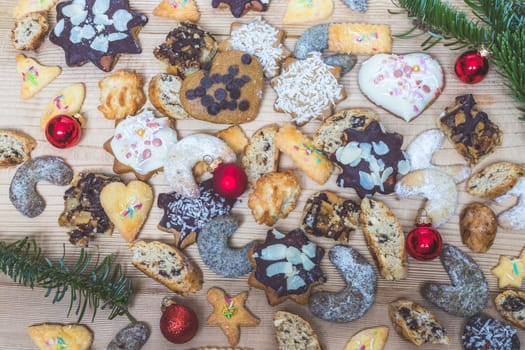 Homemade Christmas cookies, powdered sugar and Christmas bauble on a rustic wooden table