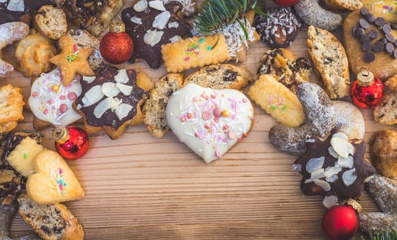 Homemade Christmas cookies, powdered sugar and Christmas bauble on a rustic wooden table. Copy Space.