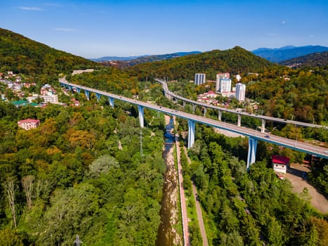 Aerial view of high bridge and mountain road with cars and truck, Sochi, Russia