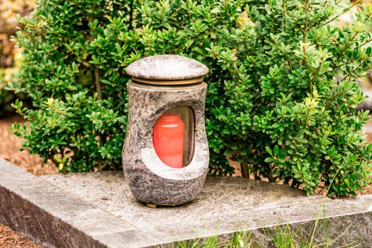 Old damaged grave lantern on a gravestone