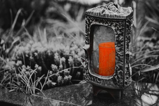 Old damaged grave lantern on a gravestone