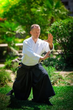 Young serious man aikido master in traditional costume