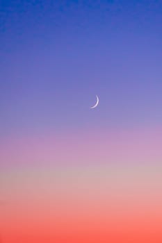 Crescent at the sunset sky. Sunset colors and new moon.