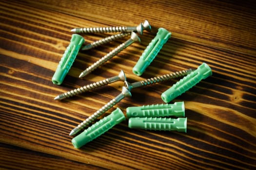 Closeup shot of a row of screws laid on a wooden table