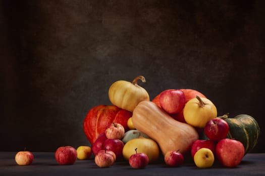 Thanksgiving background. Festive still life with pumpkins and apples on dark brown background with copy space. Happy Thanksgiving  day, autumn harvest or Halloween.