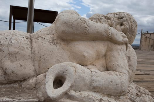 Medellin, Spain - April 28th, 2018: Old man holding an amphora. Statue-shaped fountain. Roman theatre of Medellin, Extremadura, Spain