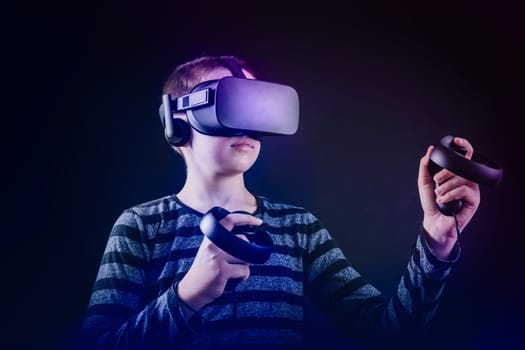 Teenager boy playing in virtual reality in neon colors, black background