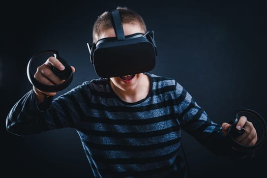 Teenager boy playing in virtual reality on black background