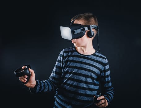 Teenager boy playing in virtual reality on black background